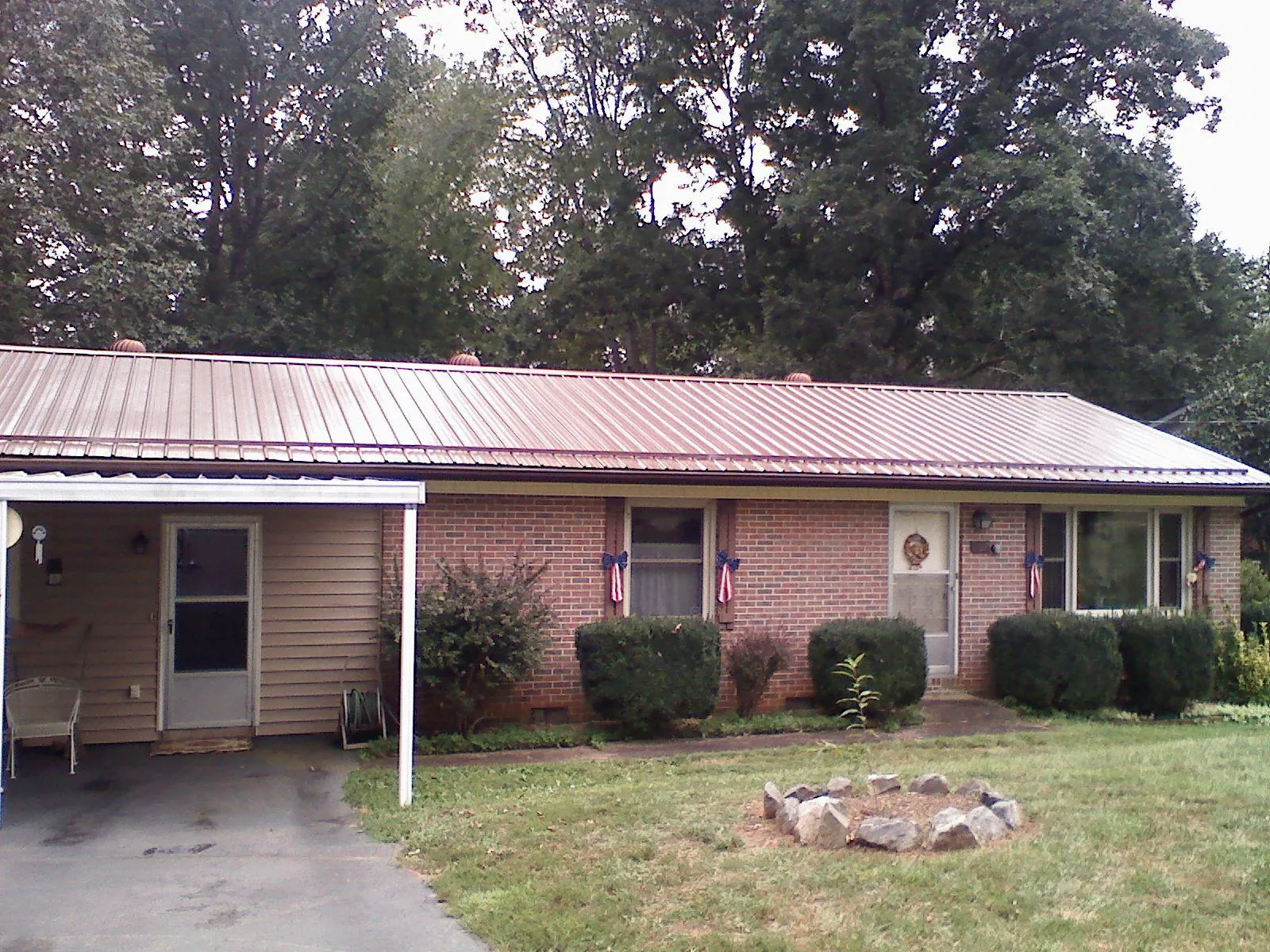 Bronze metal roof and carport on a brick ranch home — Roof Repair work by our crew in Beloit
